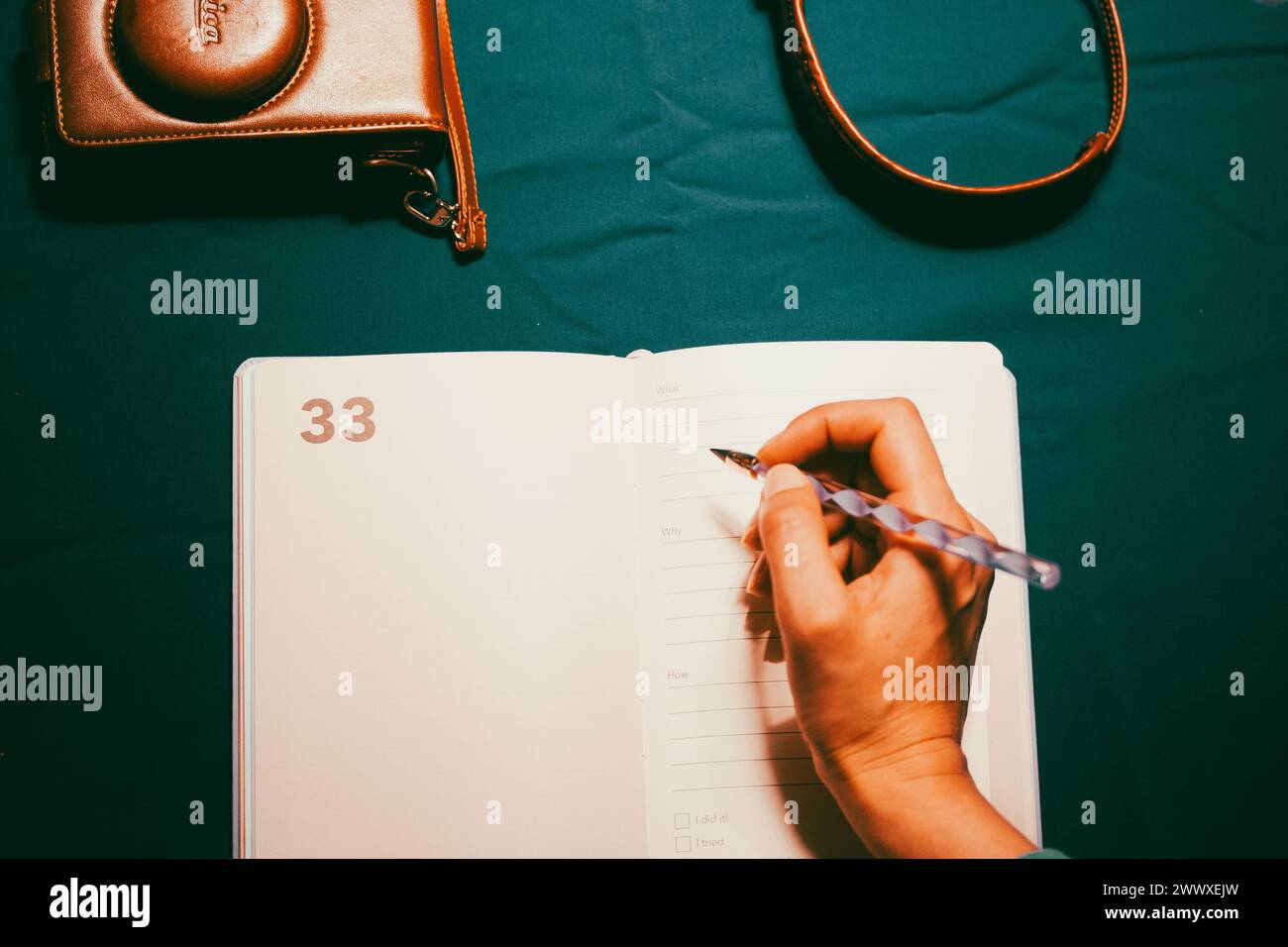 Madrid, Spagna. 5 maggio 2023 blogger di viaggio donna che scrive, prende appunti in un taccuino aperto. Fotocamera fotografica d'epoca Leica. Diario, pianificazione dell'avventura. Foto Stock