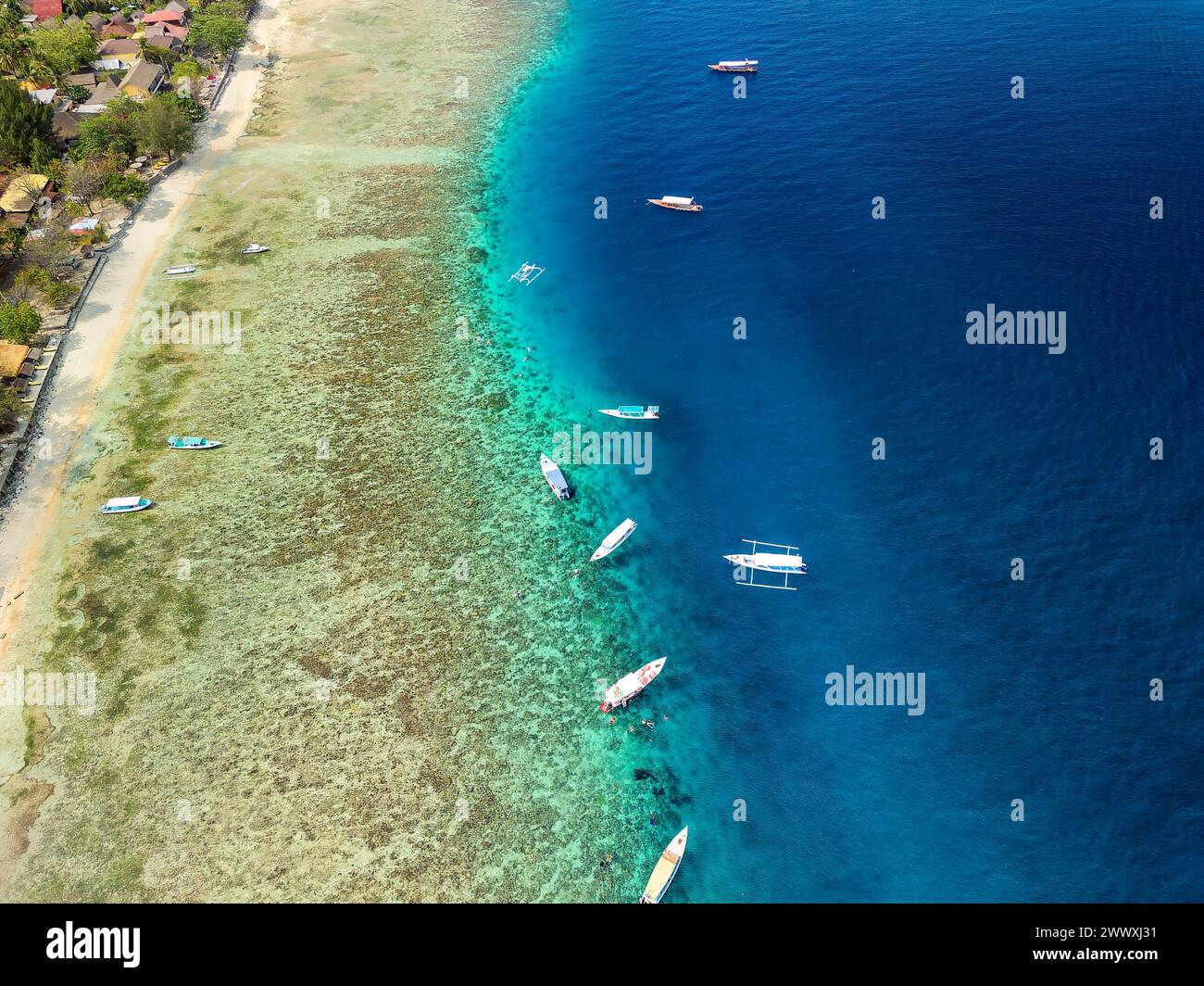 Vista aerea delle barche turistiche sulla barriera corallina su una piccola isola tropicale Foto Stock