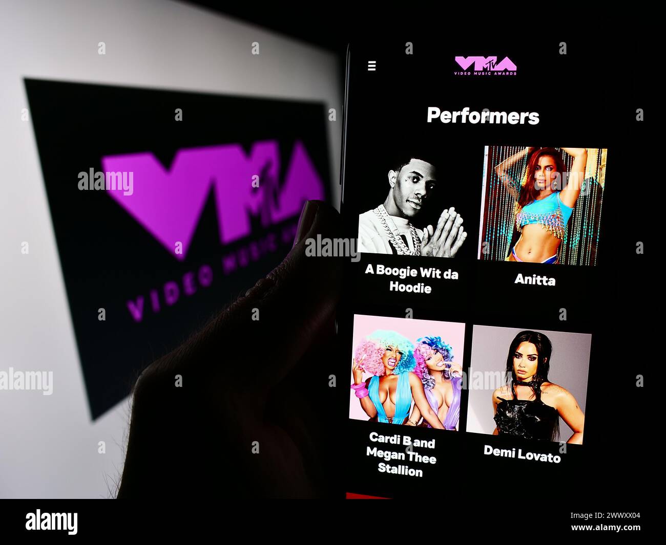 Persona che detiene un cellulare con pagina web della premiazione MTV Video Music Awards (VMA) davanti al logo. Messa a fuoco al centro del display del telefono. Foto Stock