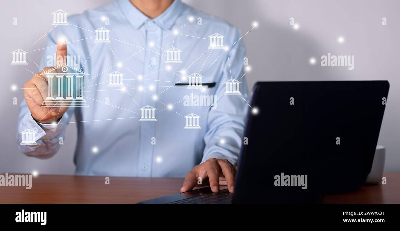 Uomo d'affari di fronte al portatile in ufficio che tocca l'icona dell'online banking e le banche di connessione di rete Foto Stock