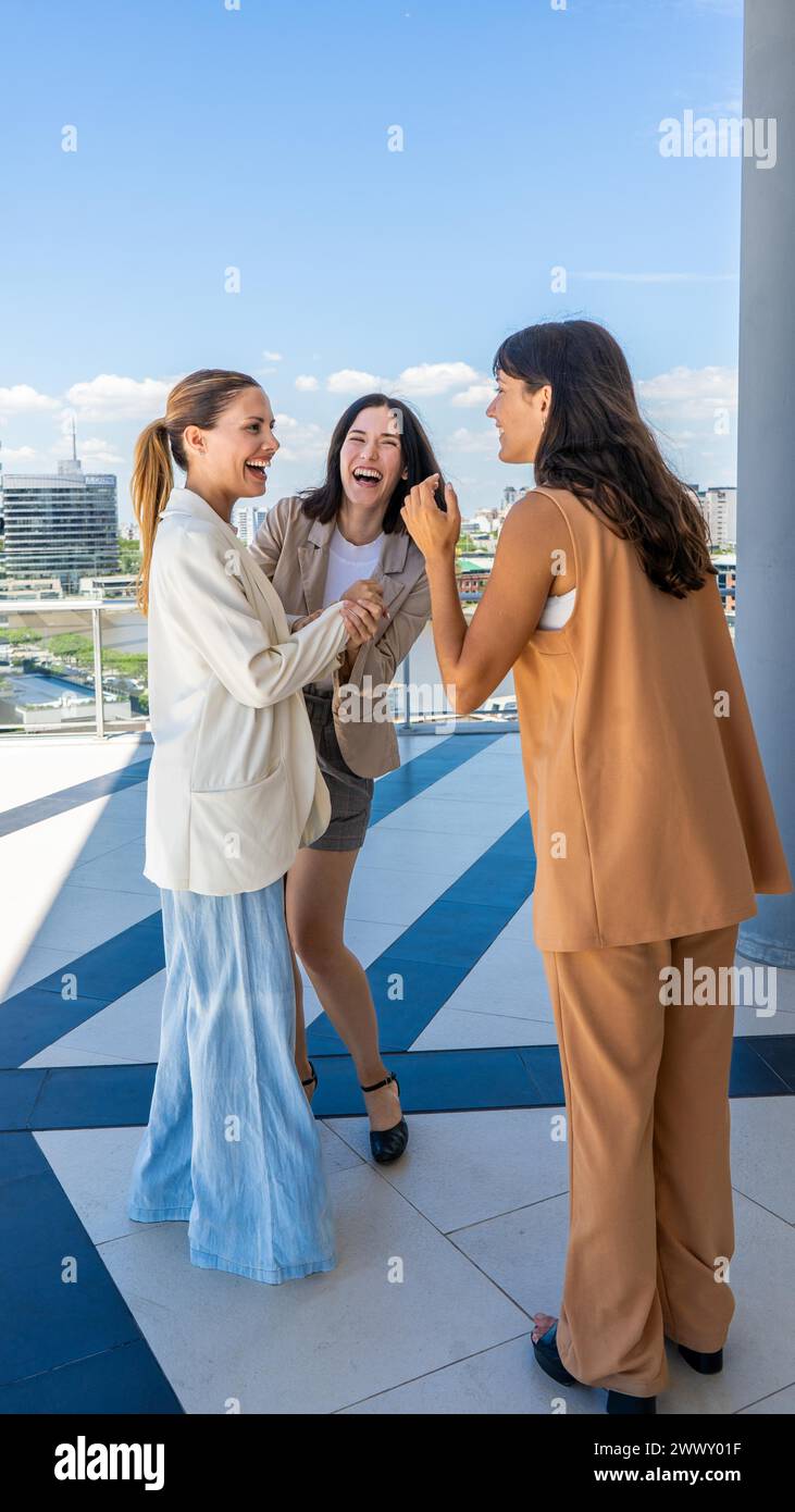 Tre donne radiose condividono un momento di gioia, le loro risate e i loro sorrisi illuminano la scena Foto Stock