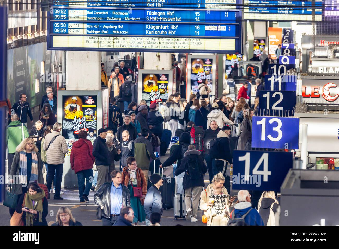 Stazione centrale, viaggiatori nella sala della piattaforma. Sul display di Stoccarda vengono comunicati estesi lavori di costruzione della rete ferroviaria Foto Stock