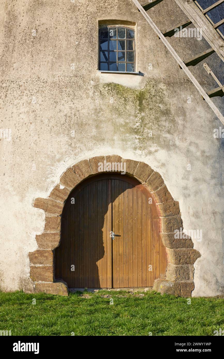 Cancello d'ingresso, finestra e parte delle ali del mulino a vento Auf der Hoechte sotto un cielo azzurro nuvoloso a Hille, Muehlenkreis Minden-Luebbecke, nord Foto Stock