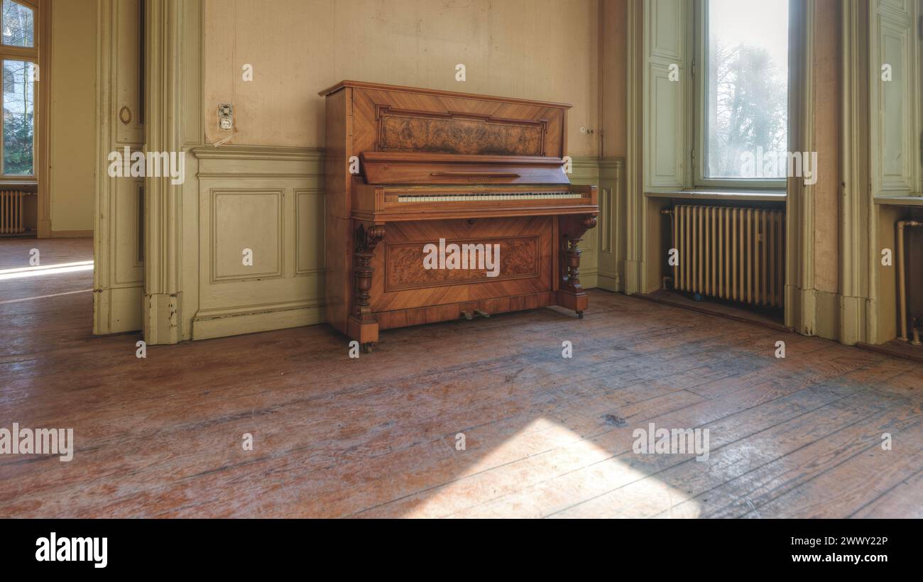 Un vecchio pianoforte a coda abbandonato in una sala con pavimento in legno e inondata di luce naturale, Villa Woodstock, Lost Place, Brill, Wuppertal, nord Foto Stock