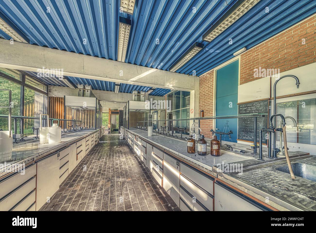 Sala di laboratorio abbandonata con lunghe panchine e contenitori di vetro sotto la luce del giorno, Istituto di Biologia molecolare, Lost Place, Sint-Genesius-Rode Foto Stock