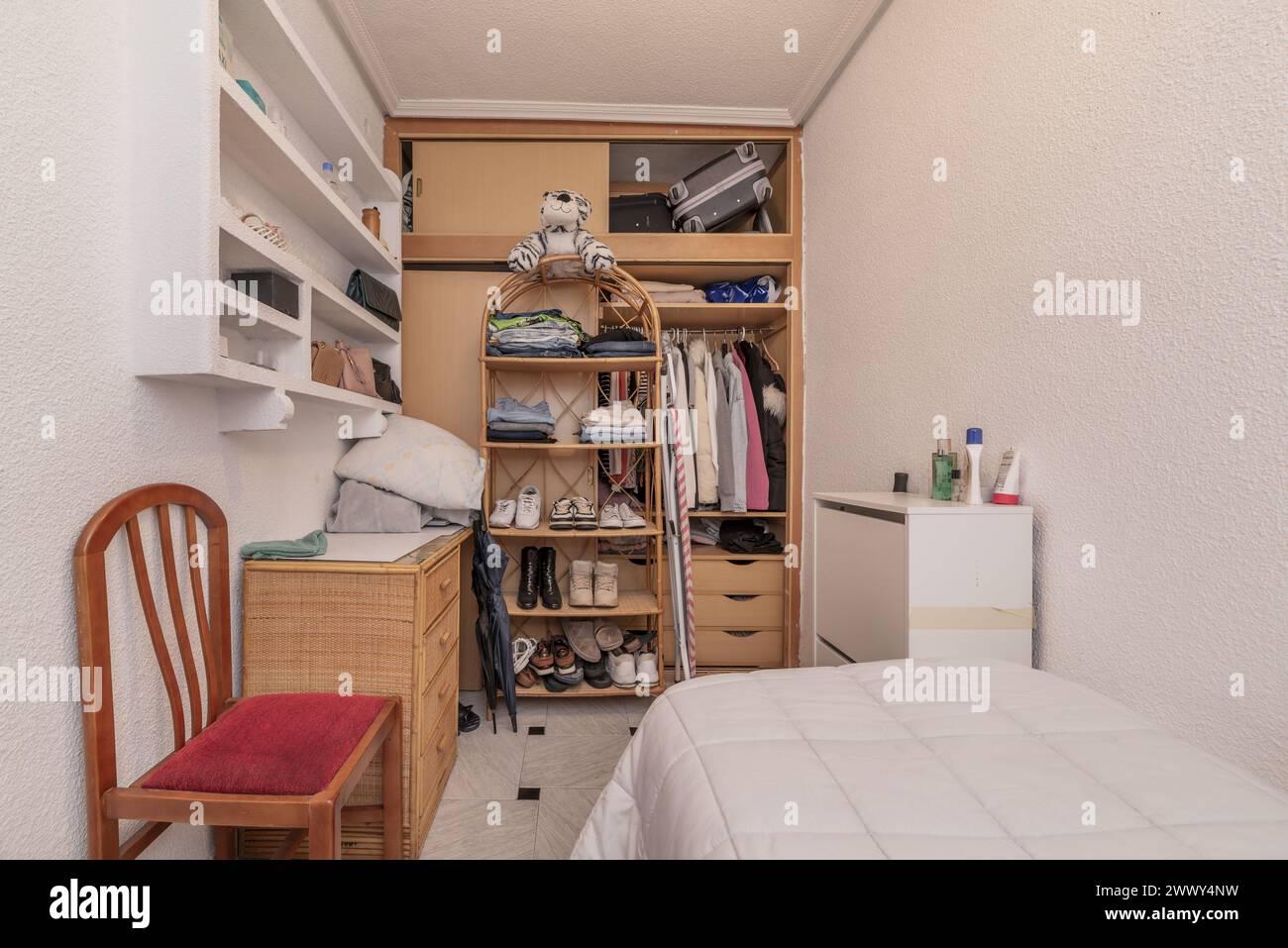camera da letto con letto singolo con armadio a muro in legno chiaro Foto Stock