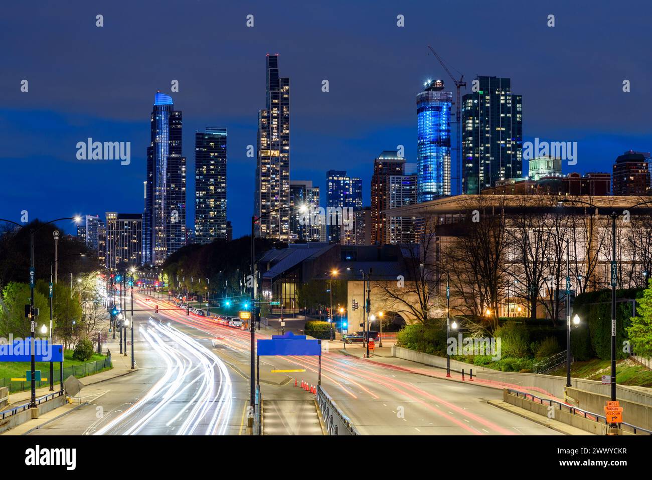 Vista di una strada principale con torri residenziali sullo sfondo di Chicago di notte Foto Stock