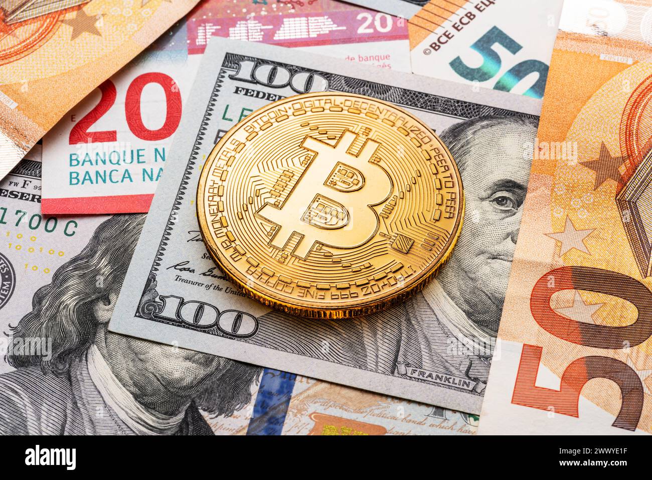 Bitcoin d'oro sullo sfondo di valute tradizionali, banconote cartacee di dollari ed euro. Foto Stock