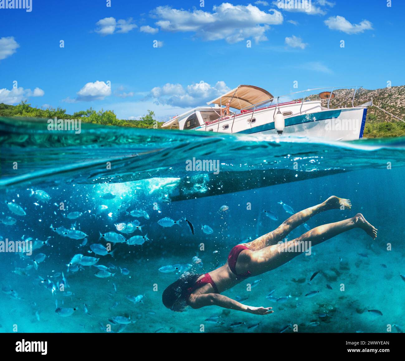 Donna subacquea sta facendo snorkeling su una bellissima spiaggia di mare. La metà inferiore del quadro è occupata dal fondale marino, in alto - la costa con uno yacht e. Foto Stock