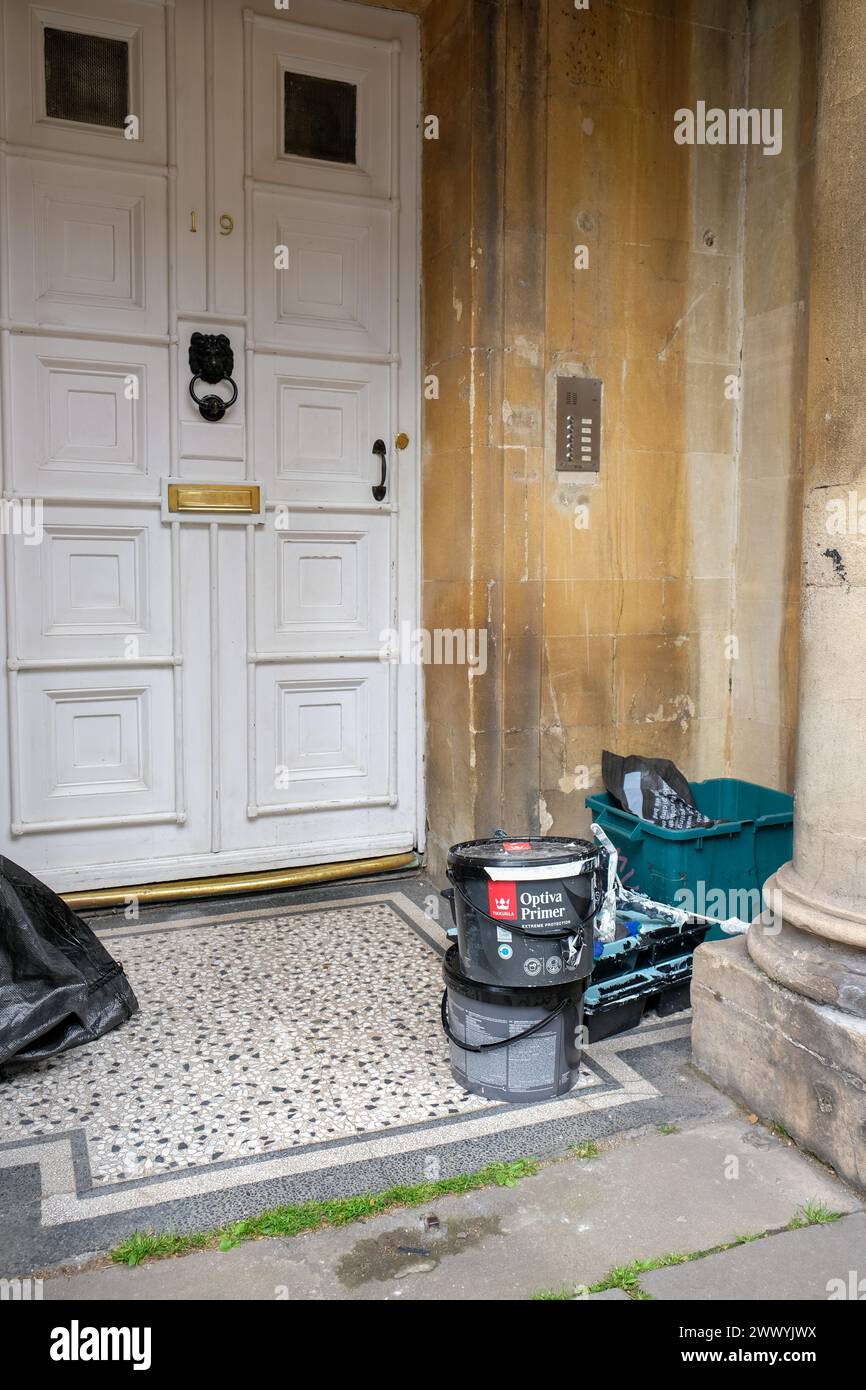 Marzo 2024 - materiali dei pittori all'ingresso di una grande casa cittadina che è stata convertita in appartamenti nella città di Bath, Inghilterra, Regno Unito. Foto Stock