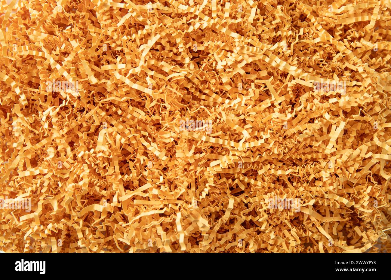 Carta grattugiata di colore giallo - sfondo del riempitivo della scatola regalo. Vista orizzontale, ripresa in studio. Foto Stock