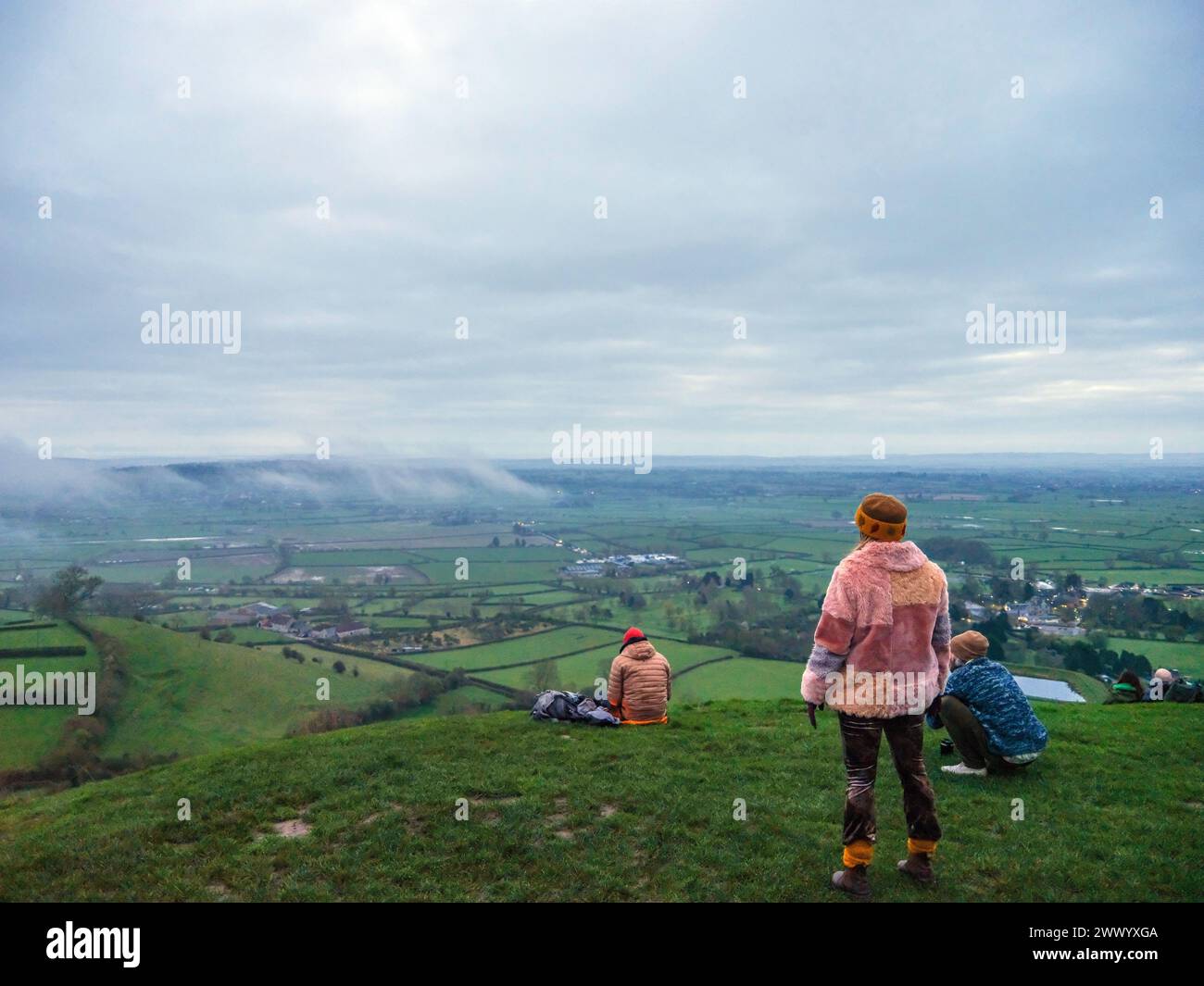 Marzo 2024 - in attesa dell'alba di Spring Equinox, in una giornata grigia nuvolosa a Glastonbury Tor, Somerset Inghilterra, Regno Unito. Foto Stock