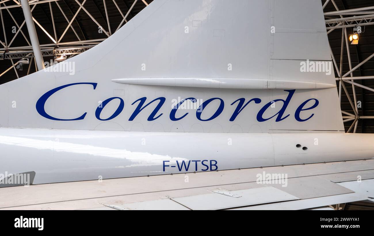 Primo piano della coda di un aereo con il logo Concorde in un hangar Foto Stock