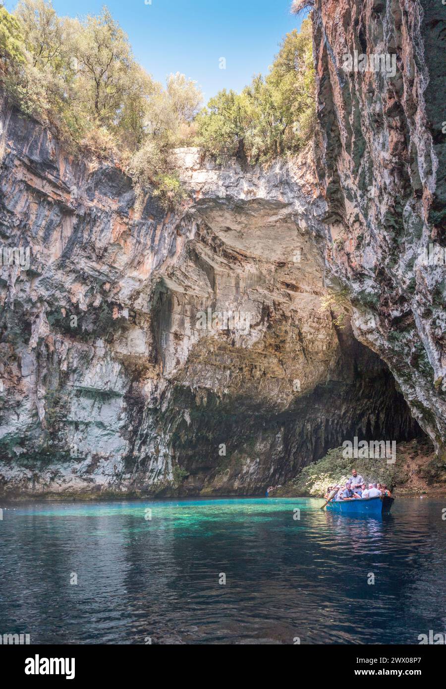 La barca turistica naviga intorno alla grotta Melissani sull'isola di Cefalonia Foto Stock