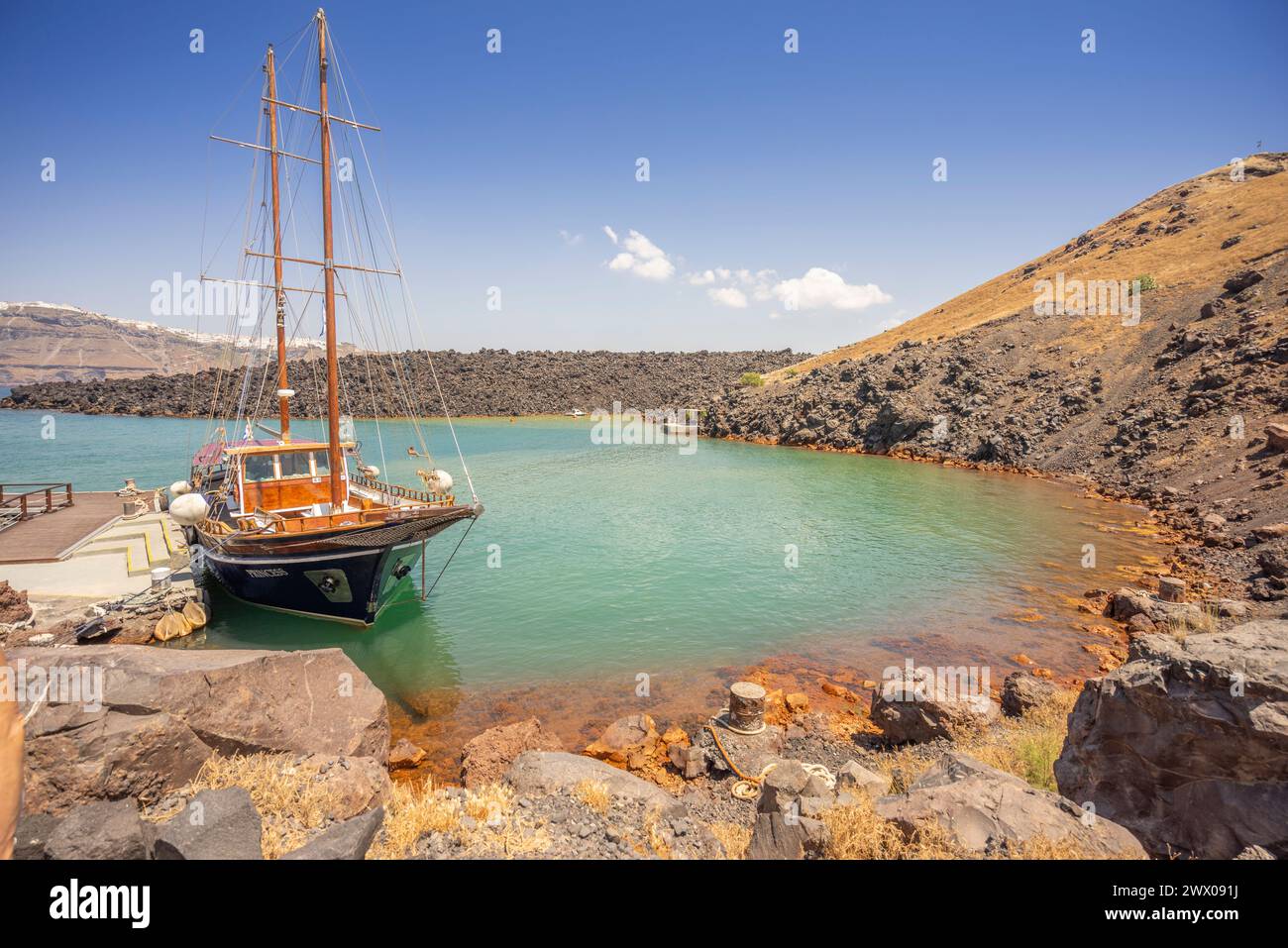 Barca turistica ormeggiata in una piccola insenatura per un'escursione a Kameni, l'isola vulcanica all'interno dell'arcipelago di Santorini. Foto Stock