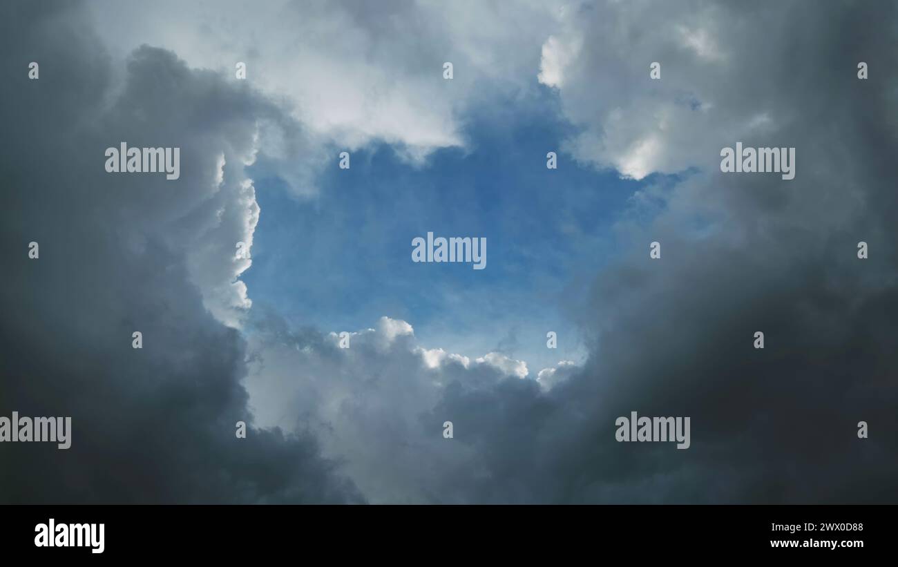 Nuvole di tempesta e buca con il cielo blu Foto Stock