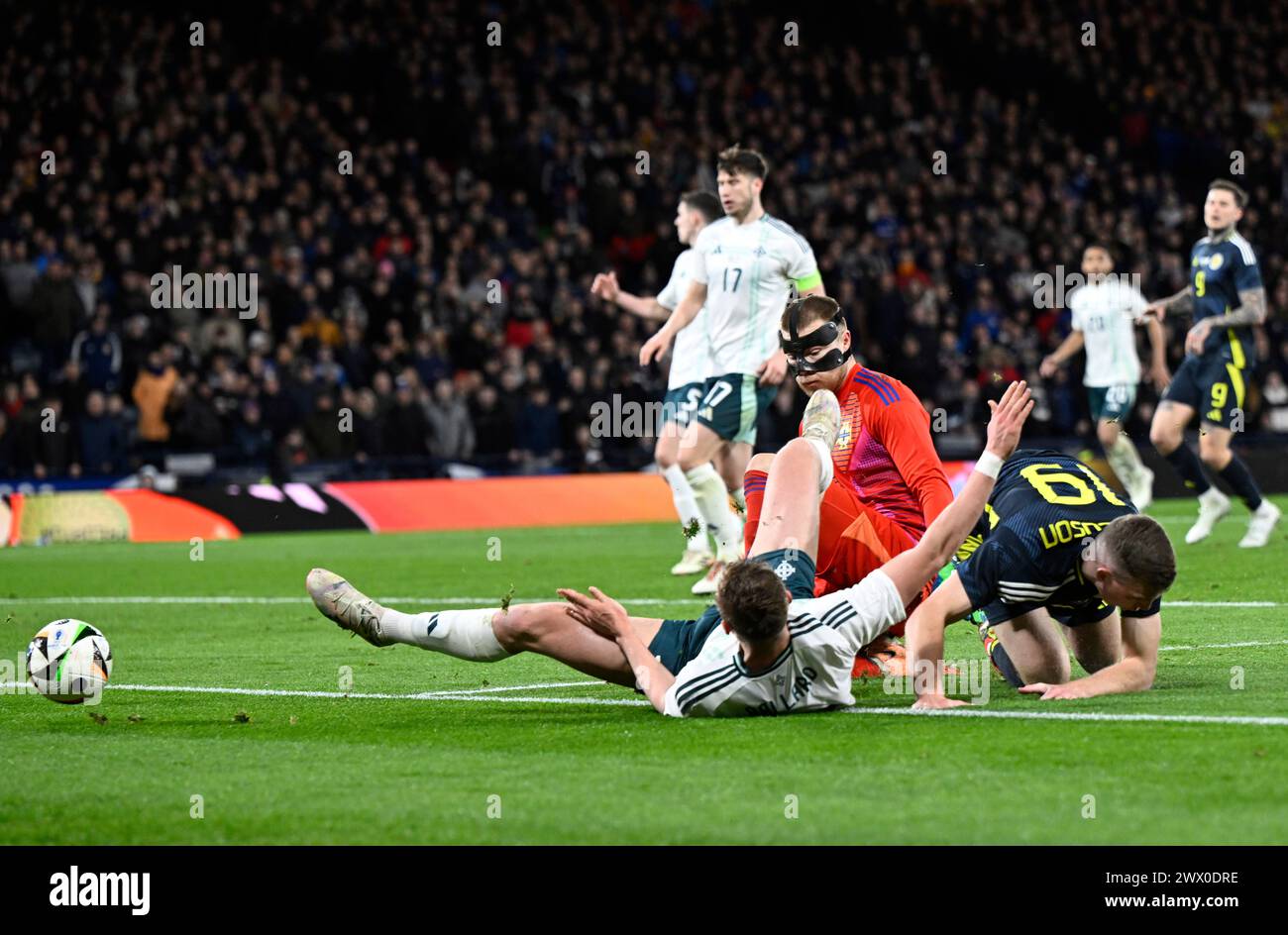 Glasgow, Regno Unito. 26 marzo 2024. Bailey Peacock-Farrell dell'Irlanda del Nord e Daniel Ballard dell'Irlanda del Nord bloccano Lewis Ferguson della Scozia durante l'amichevole internazionale a Hampden Park, Glasgow. Il credito per immagini dovrebbe essere: Neil Hanna/Sportimage Credit: Sportimage Ltd/Alamy Live News Foto Stock