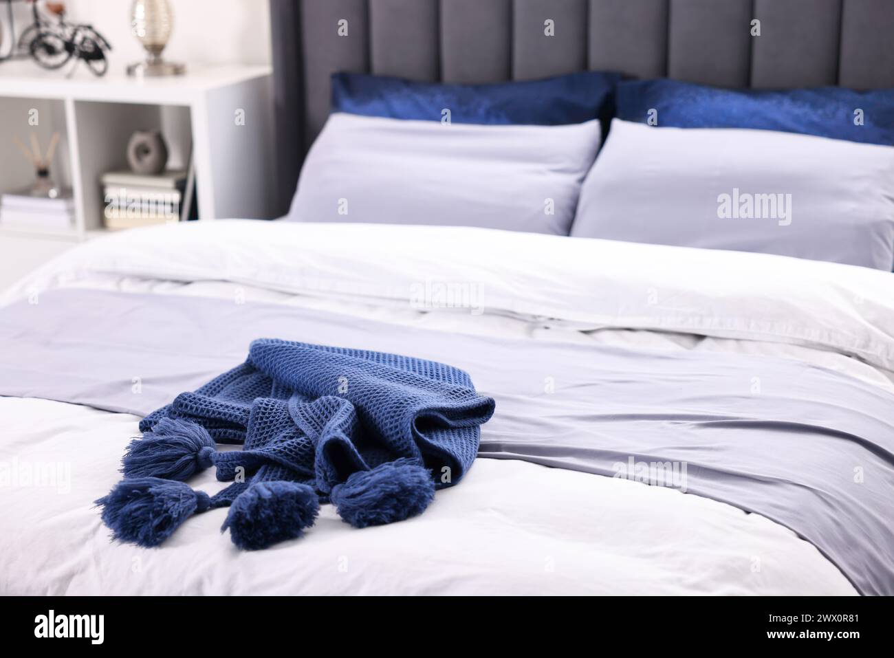 Piano blu morbido sul letto in camera, primo piano Foto Stock