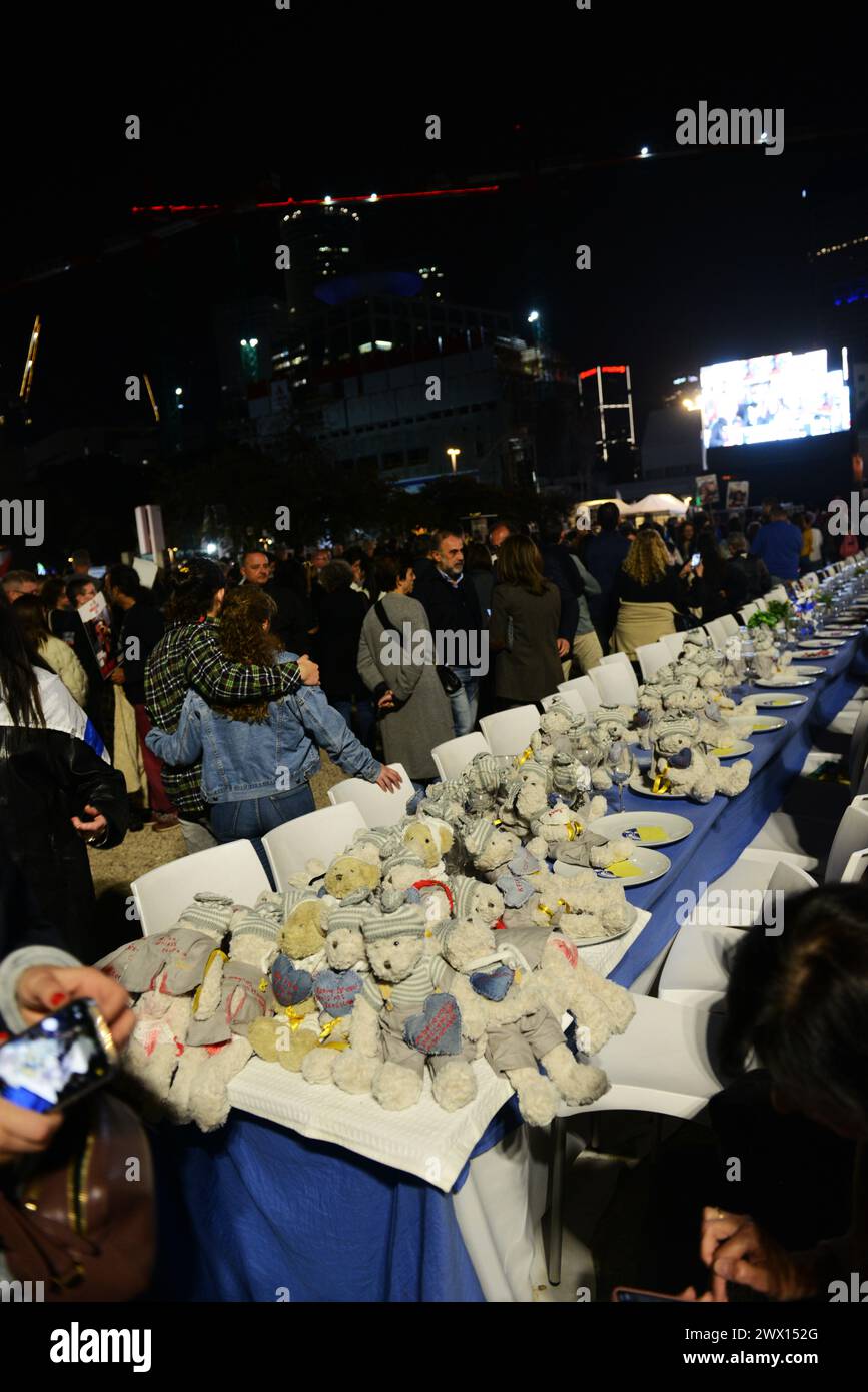 Un'installazione di un tavolo da pranzo di sabato con sedie per gli ostaggi a Gaza in Piazza degli ostaggi, Tel-Aviv, Israele. Foto Stock