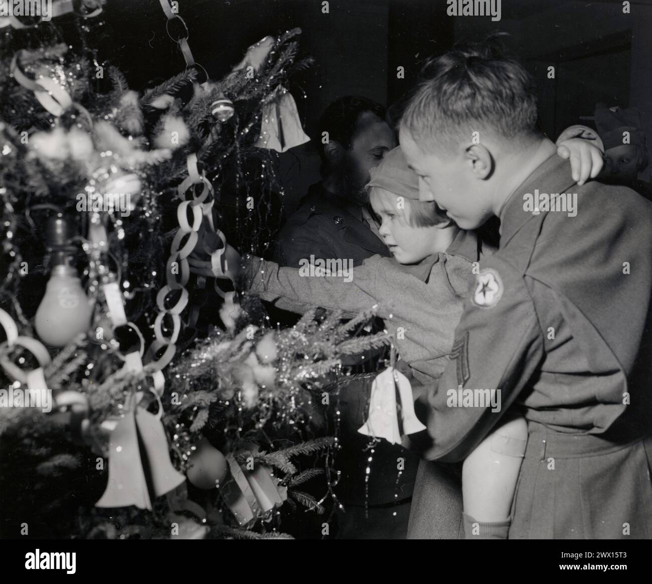 La fotografia scattata la vigilia di Natale in un ospedale americano di Londra mostra un soldato americano che tiene in braccio un bambino di quattro anni rimasto orfano da un blitz tedesco CA. 1944 Foto Stock