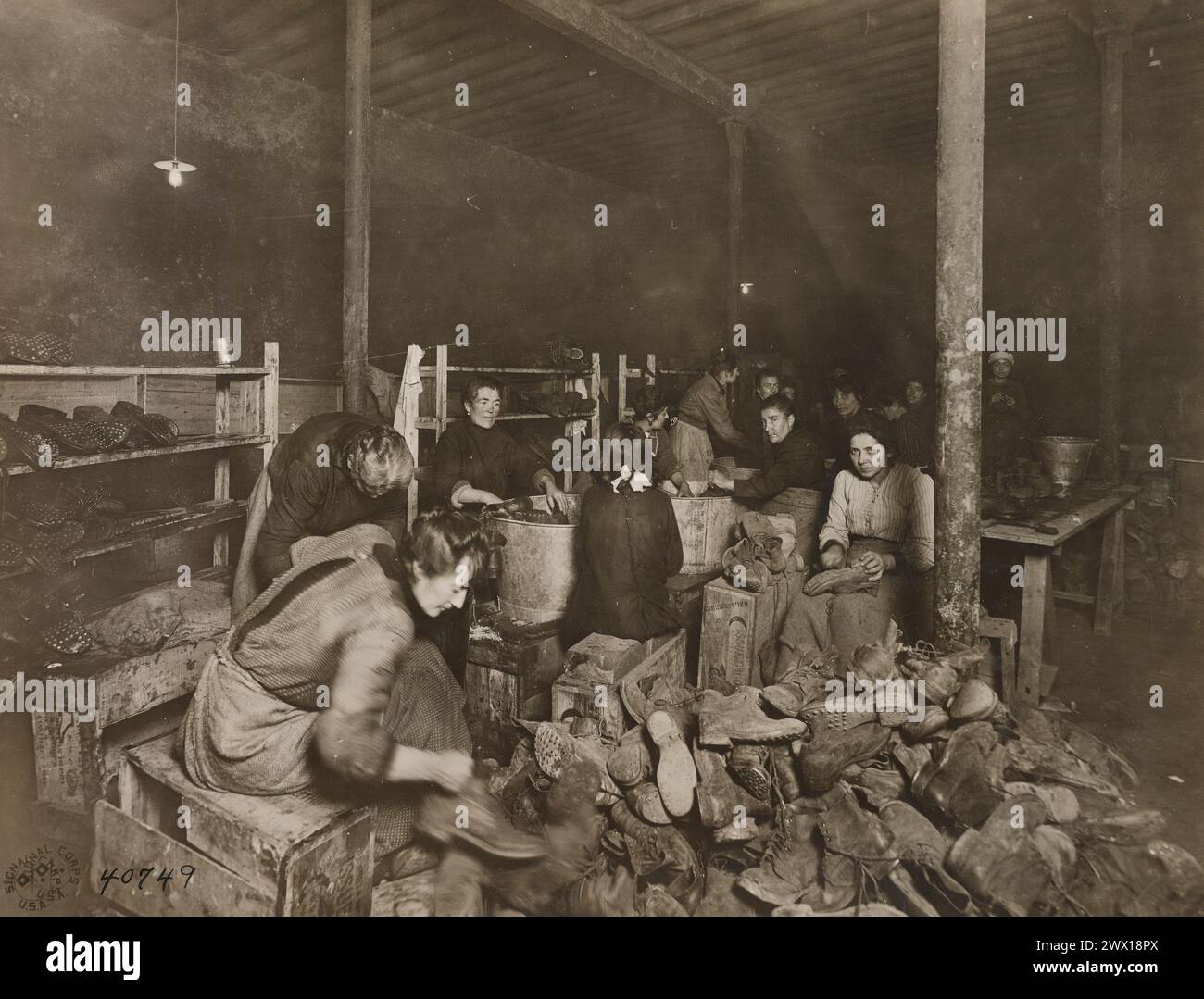 Donne che selezionano stivali in un deposito di salvataggio a Gironde Francia CA. 1918 Foto Stock