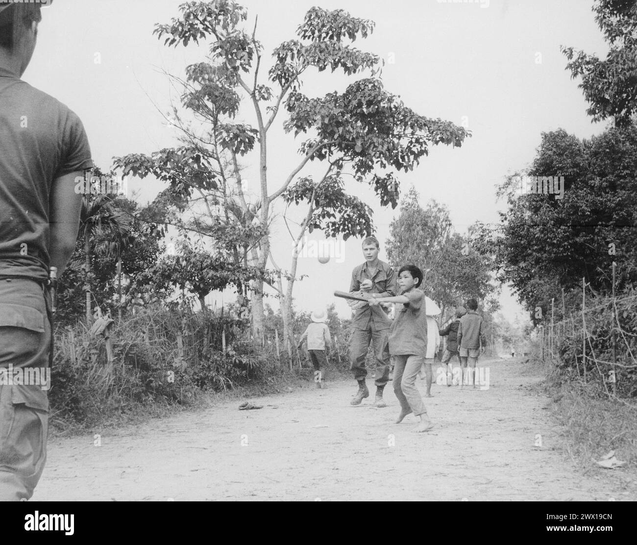 Guerra del Vietnam: I membri del 3rd Battalion, 187th Infantry, 101st Airborne Division (Airmobile), si uniscono ai figli del villaggio AP Uu Thoung in una partita di baseball CA. 1970 Foto Stock