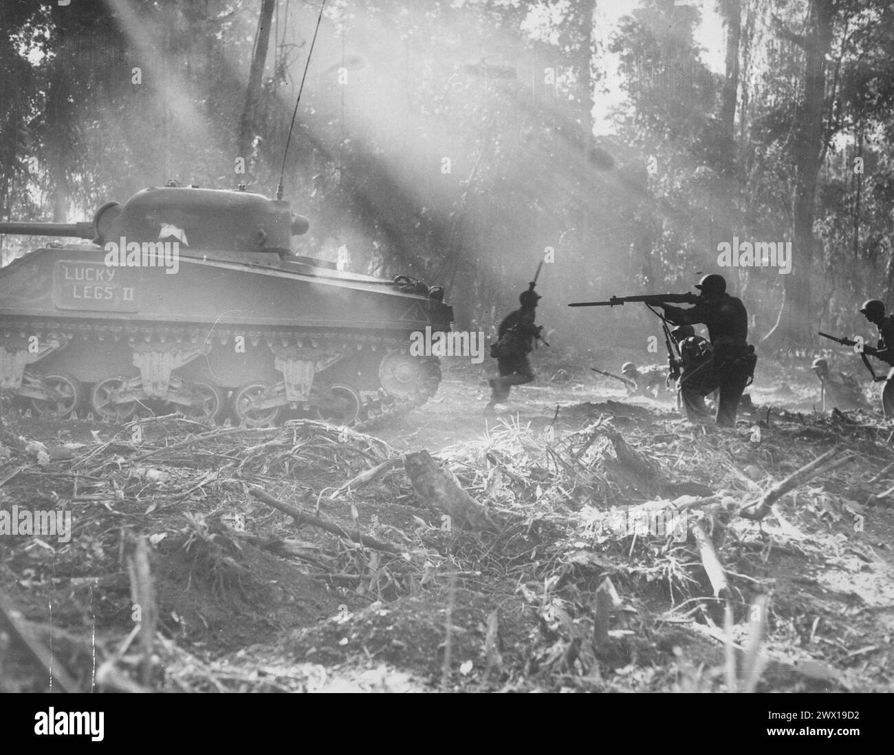 Gli Yanks si rimuovono su Bougainville. Di notte i giapponesi si infiltravano nelle linee americane. All'alba, i doughboy sono usciti e li hanno uccisi. Questa foto mostra il carro armato che va avanti, la fanteria che segue nel suo coperchio ca. Marzo 1944 Foto Stock