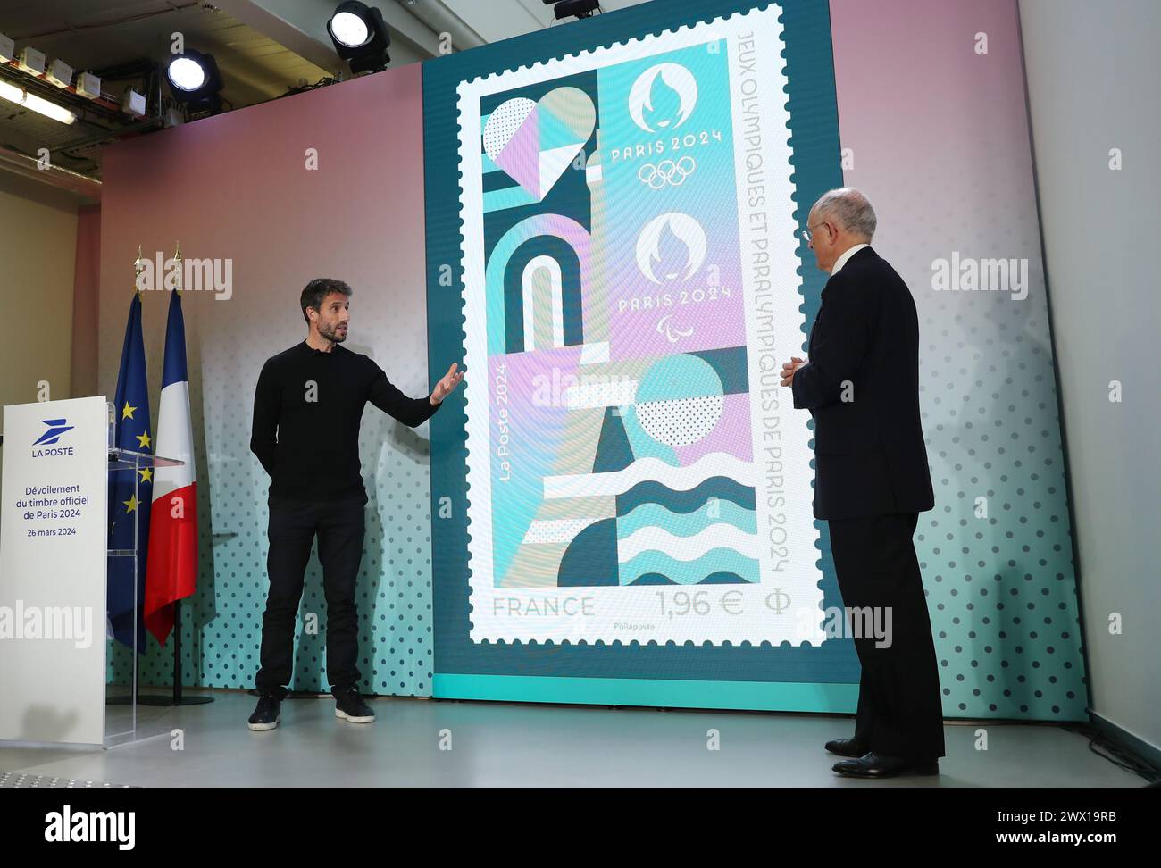 Parigi, Francia. 26 marzo 2024. Tony Estanguet (L), presidente del Comitato Organizzatore di Parigi 2024, partecipa alla cerimonia di inaugurazione del francobollo ufficiale per i Giochi Olimpici e Paralimpici di Parigi 2024 presso il Museo postale francese di Parigi, Francia, 26 marzo 2024. Traendo ispirazione dall'identità visiva delle Olimpiadi di Parigi, il francobollo mette in evidenza luoghi iconici come la Torre Eiffel e la Senna, con elementi sportivi di atletica e rimbalzi di palla in esso presenti. Il francobollo ha finiture eccezionali con stampaggio a caldo. Crediti: Gao Jing/Xinhua/Alamy Live News Foto Stock