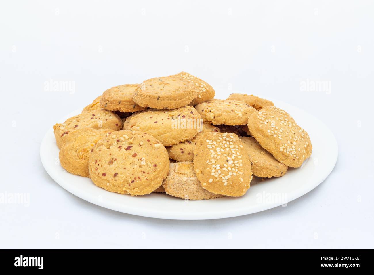 Biscotti freschi da forno misti in un piatto isolato su fondo bianco Foto Stock