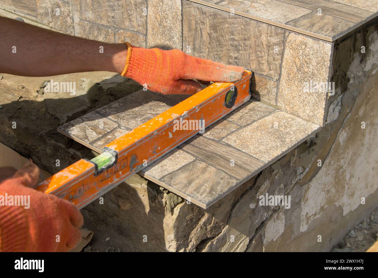 Misurazione con una livella se la tessera è disposta in modo uniforme sui gradini Foto Stock