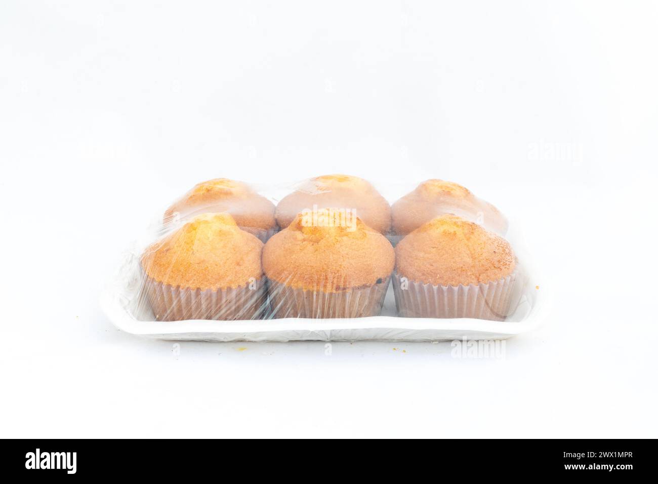 Confezione di cupcake sigillati in plastica su sfondo bianco isolato Foto Stock