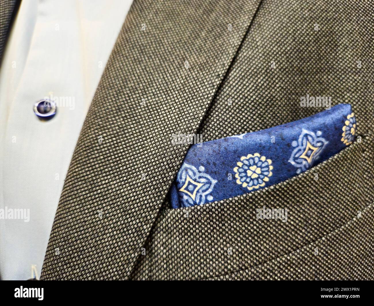 Elegante concetto di moda da uomo con un quadrato da tasca blu isolato con un abito grigio e una camicia azzurra per un look professionale e bancario Foto Stock