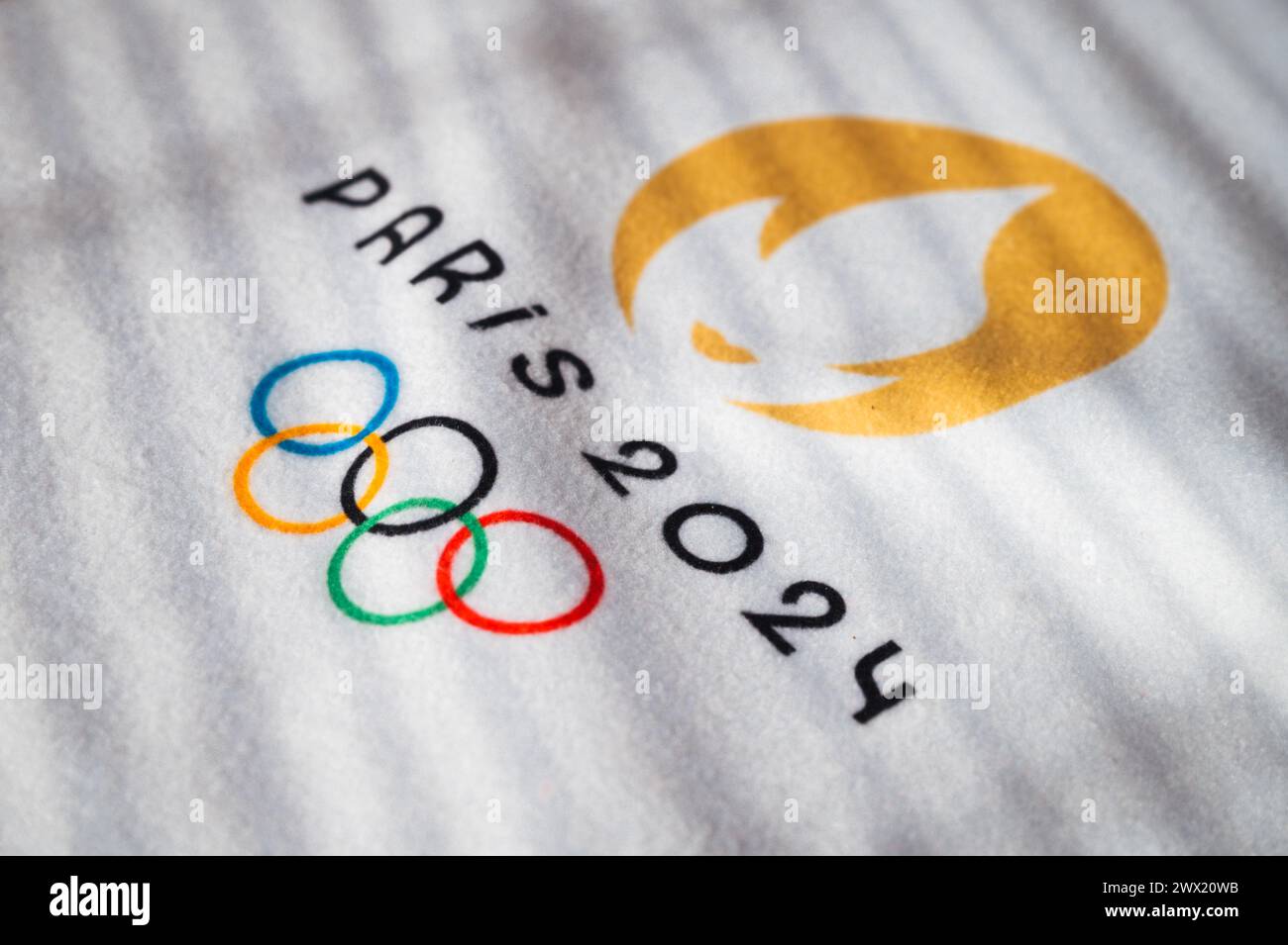 PARIGI, FRANCIA, 26 MARZO 2024: Il logo ufficiale delle Olimpiadi estive di Parigi 2024 in luce calda su asciugamano bianco Foto Stock