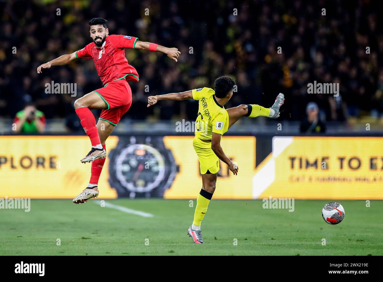 Kuala Lumpur, Malesia. 26 marzo 2024. Muhsen Saleh al Ghassani dell'Oman (L) e Muhammad Azam Azmi della Malesia in azione durante la partita di qualificazione del gruppo D della Coppa del mondo 2026/Coppa d'Asia 2027 tra Malesia e Oman allo Stadio Nazionale Bukit Jalil. Punteggio finale; Oman 2:0 Malesia. Credito: SOPA Images Limited/Alamy Live News Foto Stock