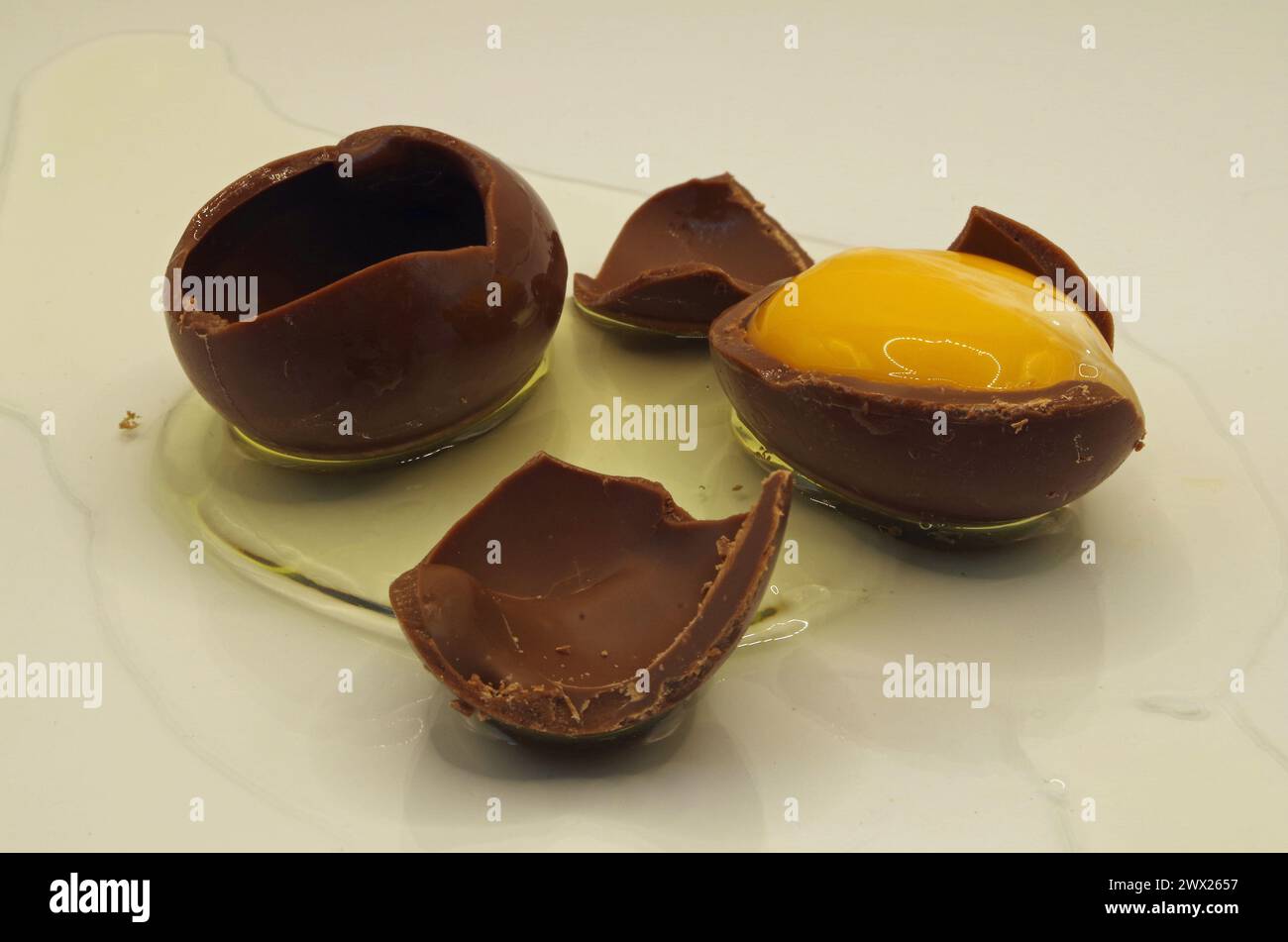 Uovo di cioccolato rotto con tuorlo d'uovo vero e bianco d'uovo. Foto Stock