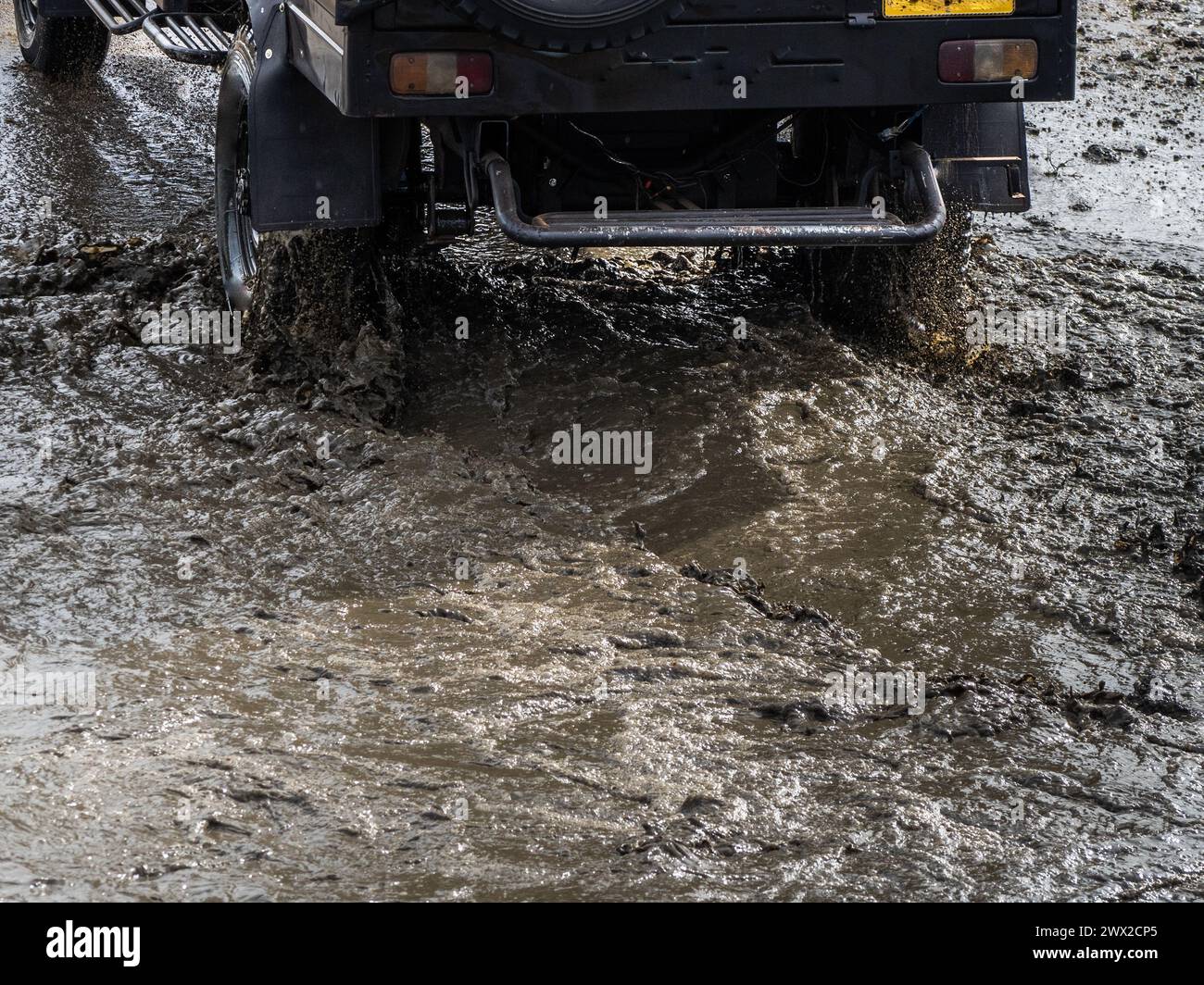 Jeep fuoristrada su strada ghiaia. Fango e acqua si tuffano nelle corse fuoristrada. Guida fuoristrada su strada di montagna Foto Stock
