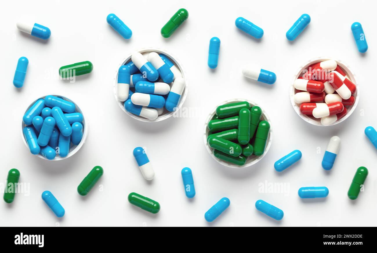 Pillole mediche su sfondo bianco, vista dall'alto. Primo piano sugli integratori alimentari colorati. Bel motivo. Banner panoramico. Varie vitamine, assortite Foto Stock