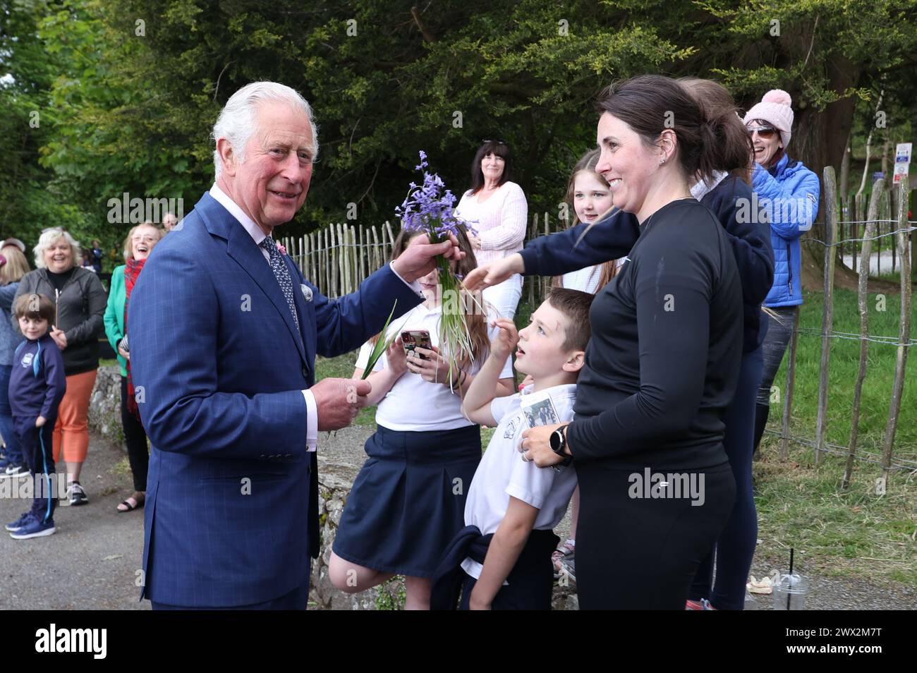 La foto del file datata 18/05/21 del Principe di Galles riceve un mazzo di fiori da un membro del pubblico mentre accoglie le persone nel parcheggio durante una visita al Parco forestale Slieve Gullion a Meigh, Newry. Burberry ha lanciato una nuova collezione di sciarpe e trench - con la famosa fodera a quadri scambiata con illustrazioni floreali ispirate a Highgrove. Data di pubblicazione: Mercoledì 27 marzo 2024. Foto Stock