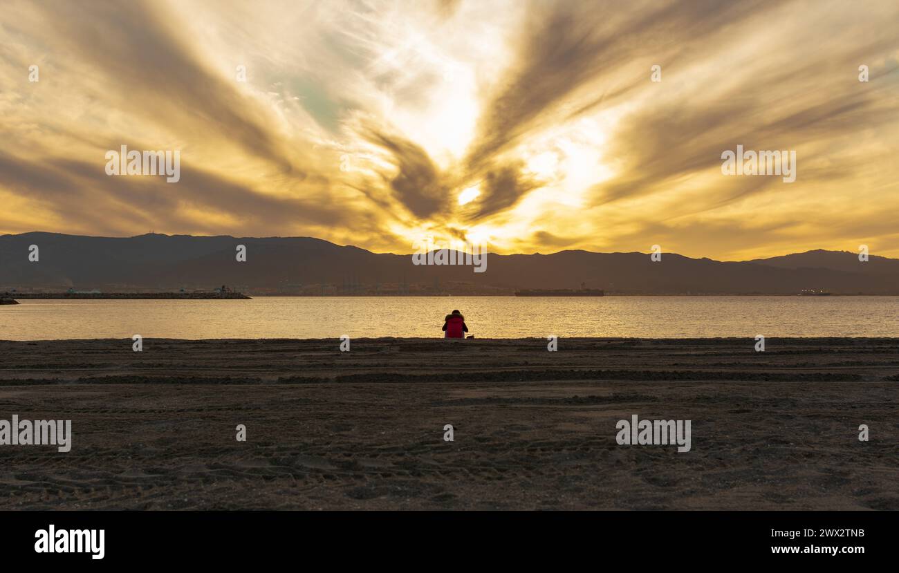 donna solitaria che meditava sulla spiaggia Foto Stock