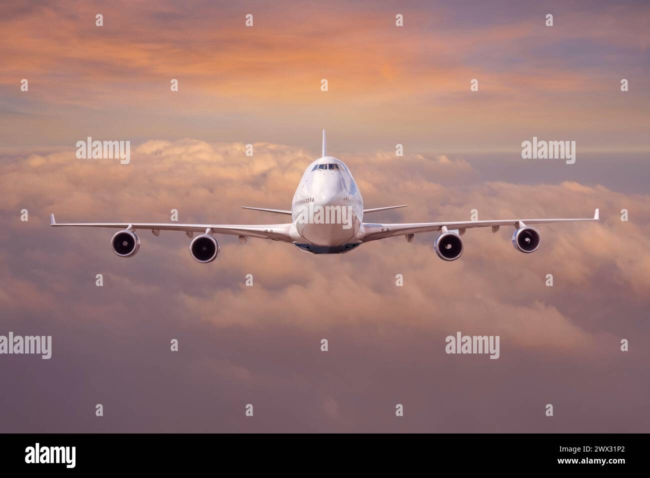 Aereo civile passeggeri jet che vola a livello di volo in alto nel cielo sopra le nuvole cielo arancione tramonto Foto Stock