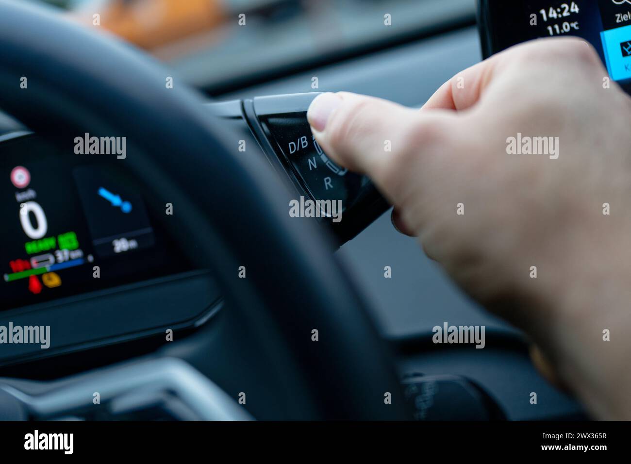 Colonia, Germania. 13 marzo 2024. In un'auto elettrica, viene utilizzato un selettore del cambio per selezionare la marcia avanti e la retromarcia e il livello di recupero. Credito: Henning Kaiser/dpa/Alamy Live News Foto Stock