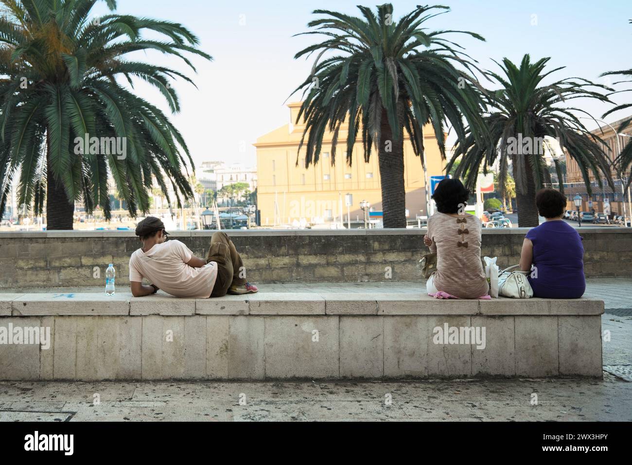 Persone sedute sulla panchina di Bari, in Italia Foto Stock