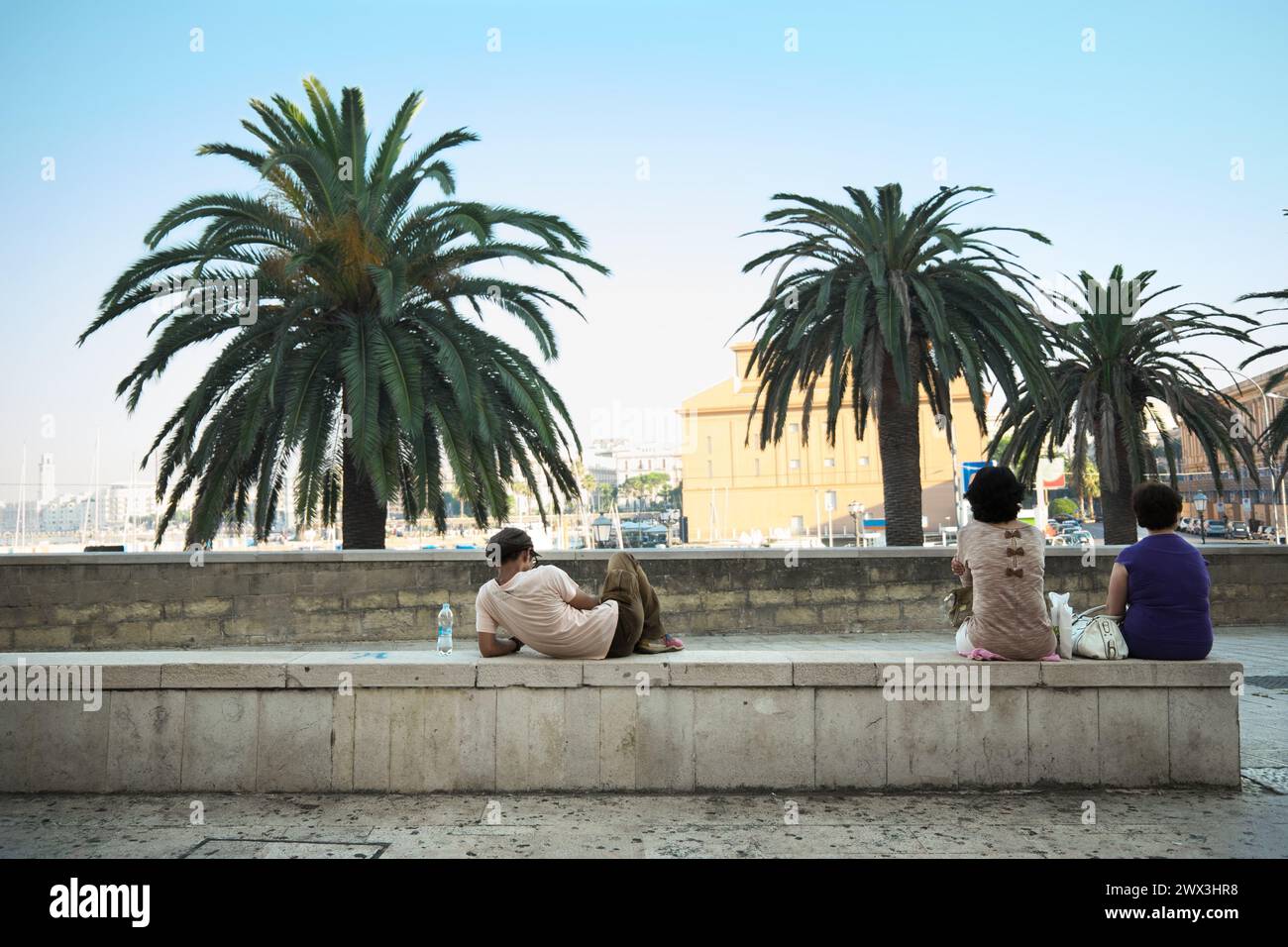 Persone sedute sulla panchina di Bari, in Italia Foto Stock