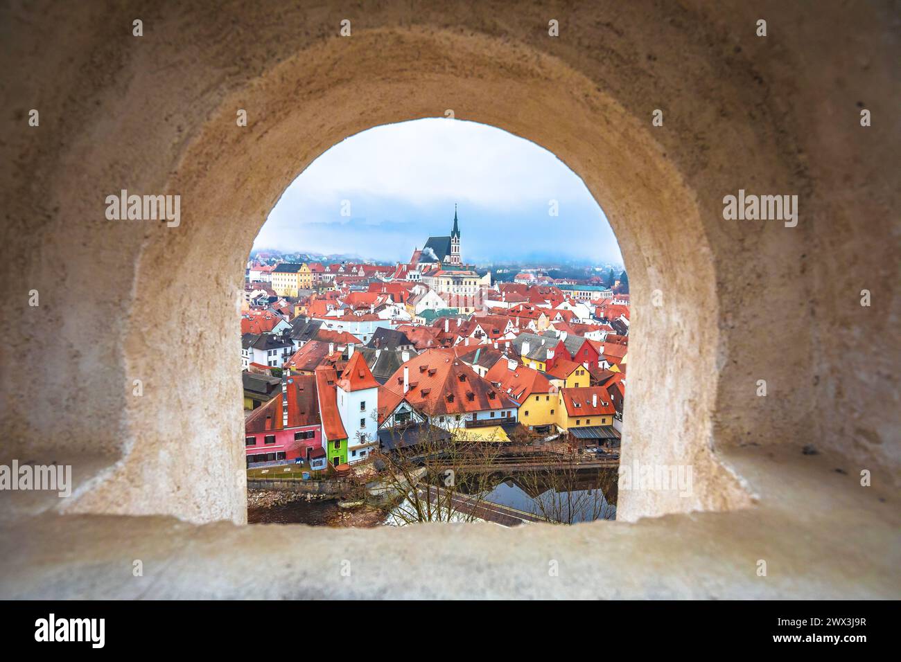 Vista panoramica della città di Cesky Krumlov e del fiume Moldava attraverso la finestra in pietra, regione della Boemia meridionale della Repubblica Ceca Foto Stock