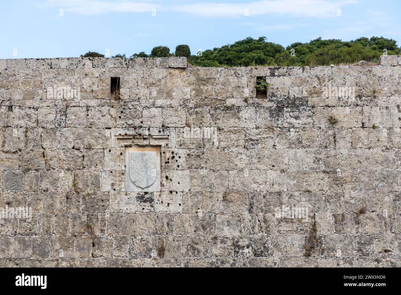 Muro di pietra fortificata a Rodi, Grecia. Buchi di proiettile danno bellico visibile. Foto Stock