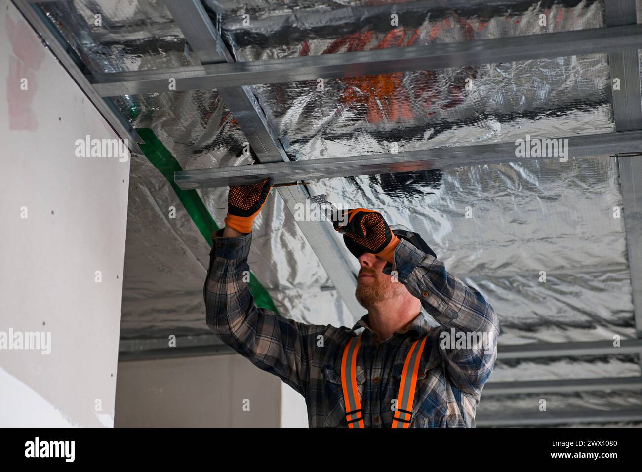 Costruzione di cartongesso a casa. installazione di un telaio metallico sul soffitto. Foto Stock