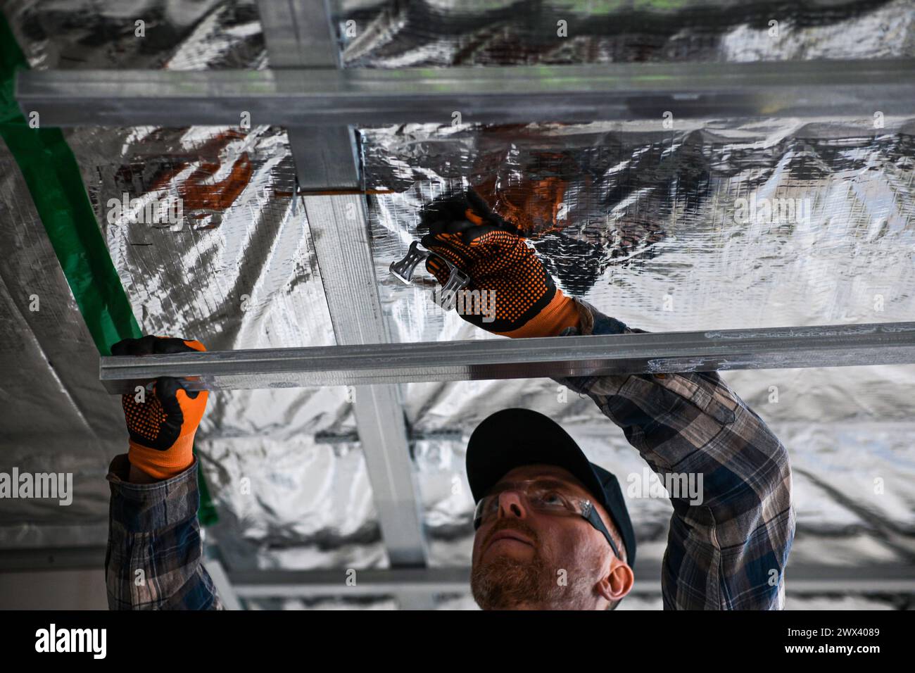 Costruzione di cartongesso a casa. installazione di un telaio metallico sul soffitto. Foto Stock