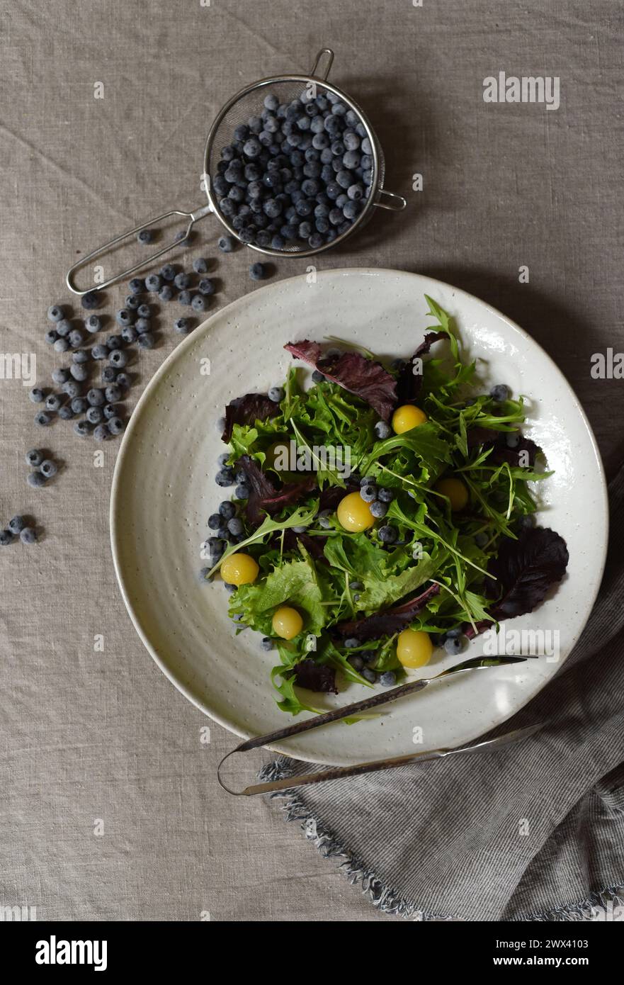 Verdure, pomodori gialli e mirtilli per un'insalata. Foto Stock