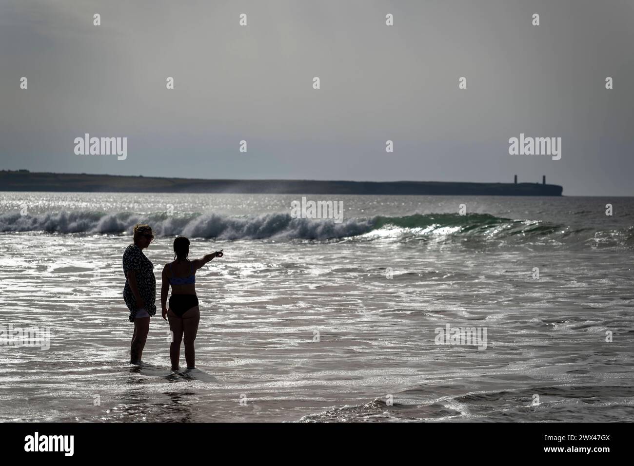 05.09.2023, Irland Land und Leute, Surfer- und Küstenstadt Tramore bei Waterford Irland im Südosten. Mutter und Tochter stehen am Strand im Wasser und schauen aufs Meer hinaus. 05.09.2023, Irland Land und Leute 05.09.2023, Irland Land und Leute *** 05 09 2023, Irlanda, Surfers e città costiera Tramore vicino a Waterford Irlanda a sud-est madre e figlia stanno sulla spiaggia in acqua e si affacciano sul mare 05 09 2023, paese e popolazione dell'Irlanda 05 09 2023, paese e popolazione dell'Irlanda Foto Stock