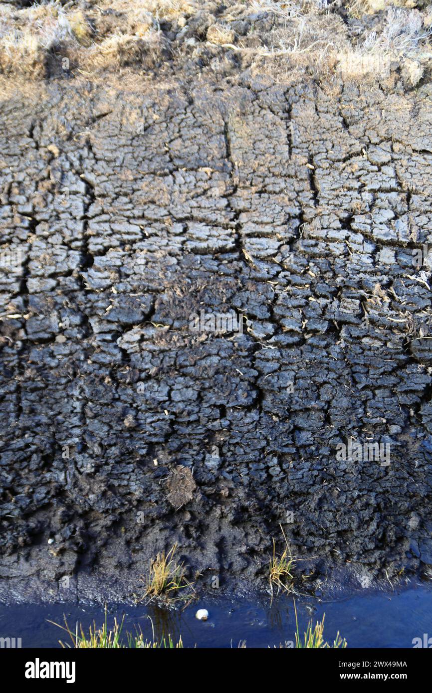Parete verticale di torba, che termina in un fosso acquoso sul fondo, sull'isola di Mull in Scozia Foto Stock